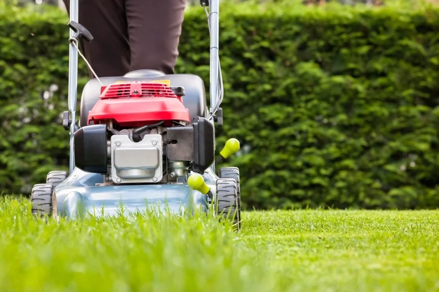 A person using a string trimmer to edge a lawn in Shadelands, Concord, CA 94519.